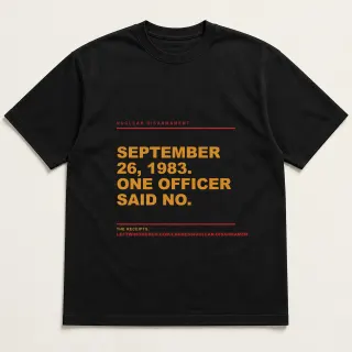 Front of a black tee reading "September 26, 1983. One officer said no." with the Nuclear Disarmament page address printed under it